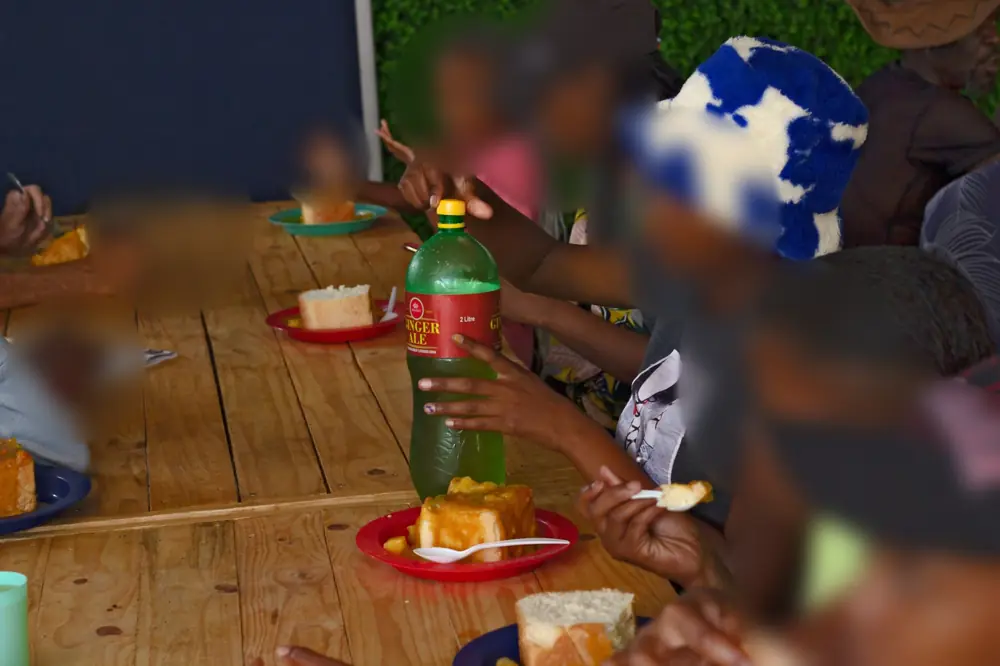 Kids sharing bread and cool drink at the table