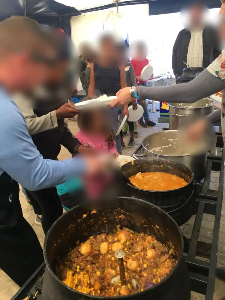Volunteers dishing up pots of stew